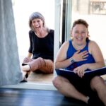 Two white actors, one beautiful woman, one beautiful non binary person sit side by side and laugh joyfully. It is all happiness.