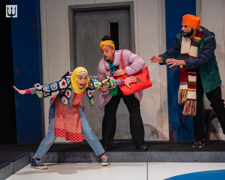 A Syrian girl in a bright yellow hijab slipping on ice in a curling rink. A Black woman and Indian man in bright warm clothes rush to help her so she doesn't fall.